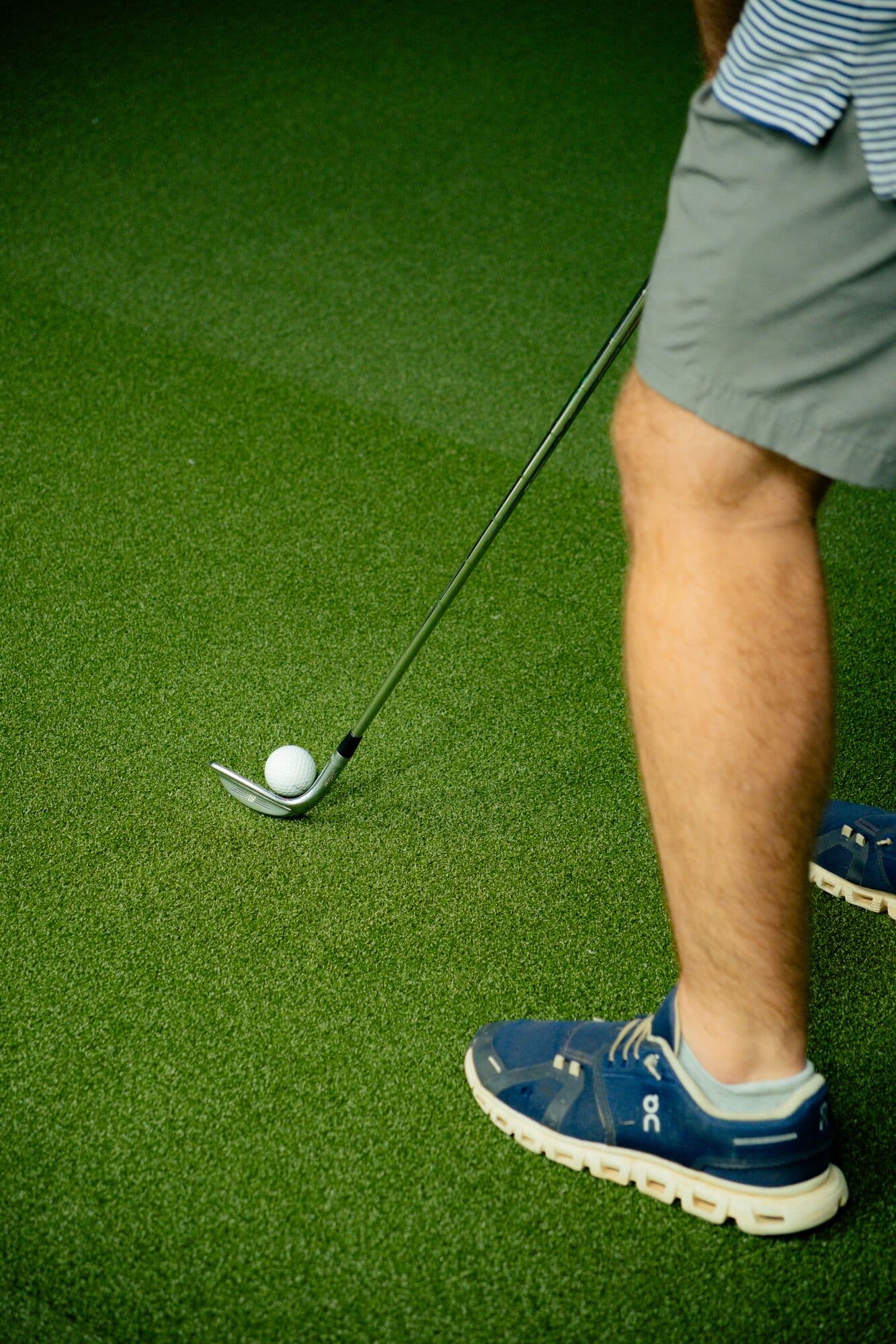 Close-up of a golfer setting up to a ball on the turf