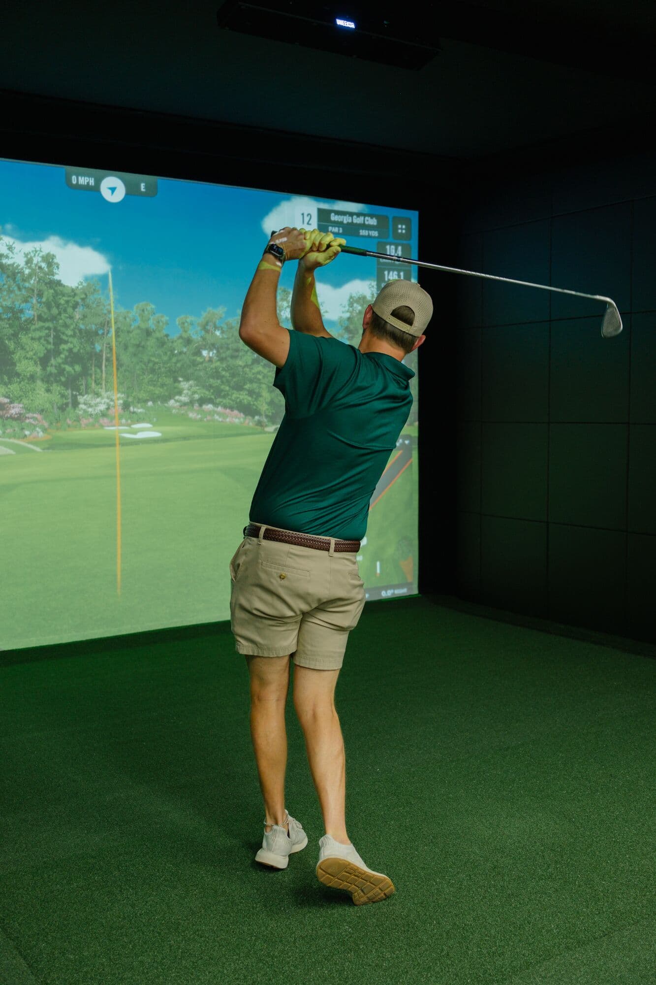 A golfer holding his finish after a drive on the simulator
