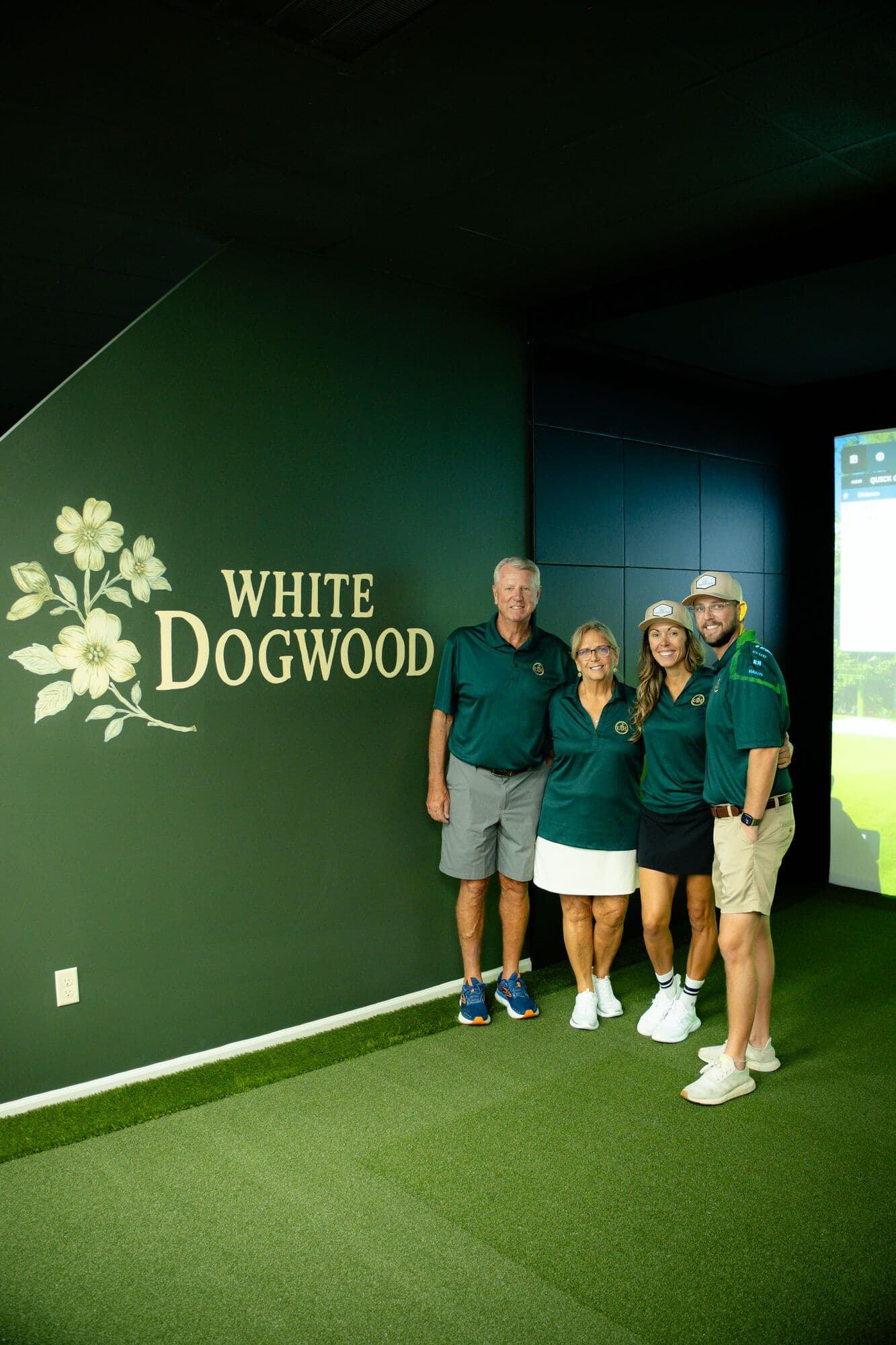 The Upstate Teehouse team in green polos in front of the White Dogwood bay sign